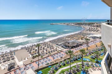 a beach with many chairs and umbrellas