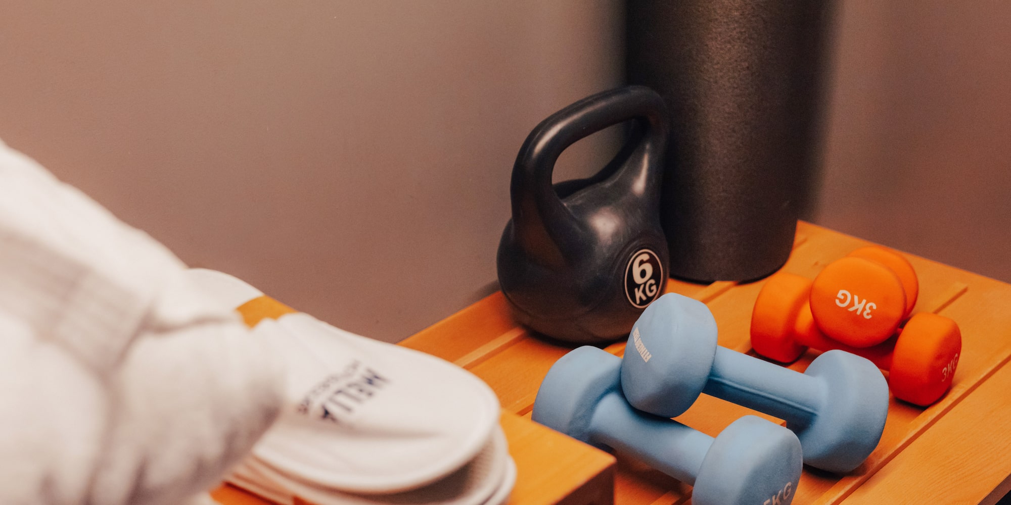 Hotel fitness equipment: kettlebell, dumbbells, and slippers.