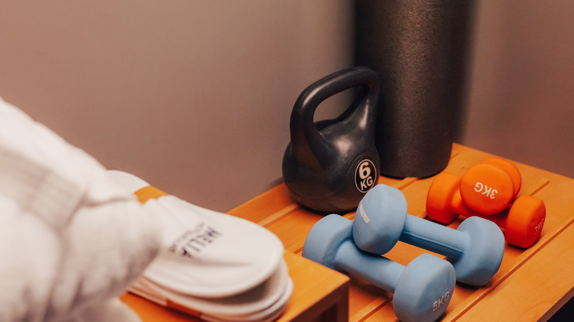 Hotel fitness equipment: kettlebell, dumbbells, and slippers.