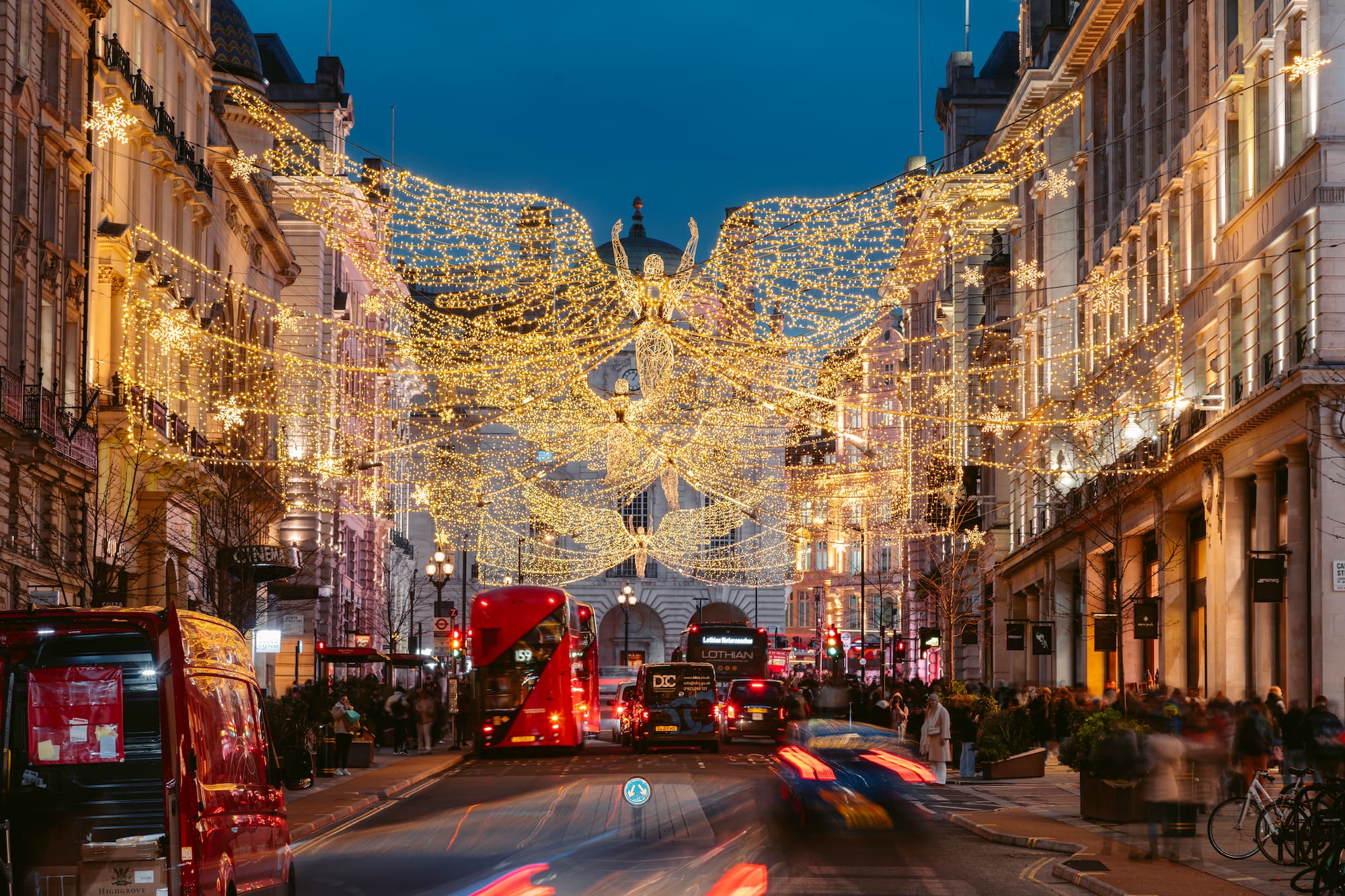 Luces de Navidad en Regent Street, Londres, con ángel alado y tráfico.