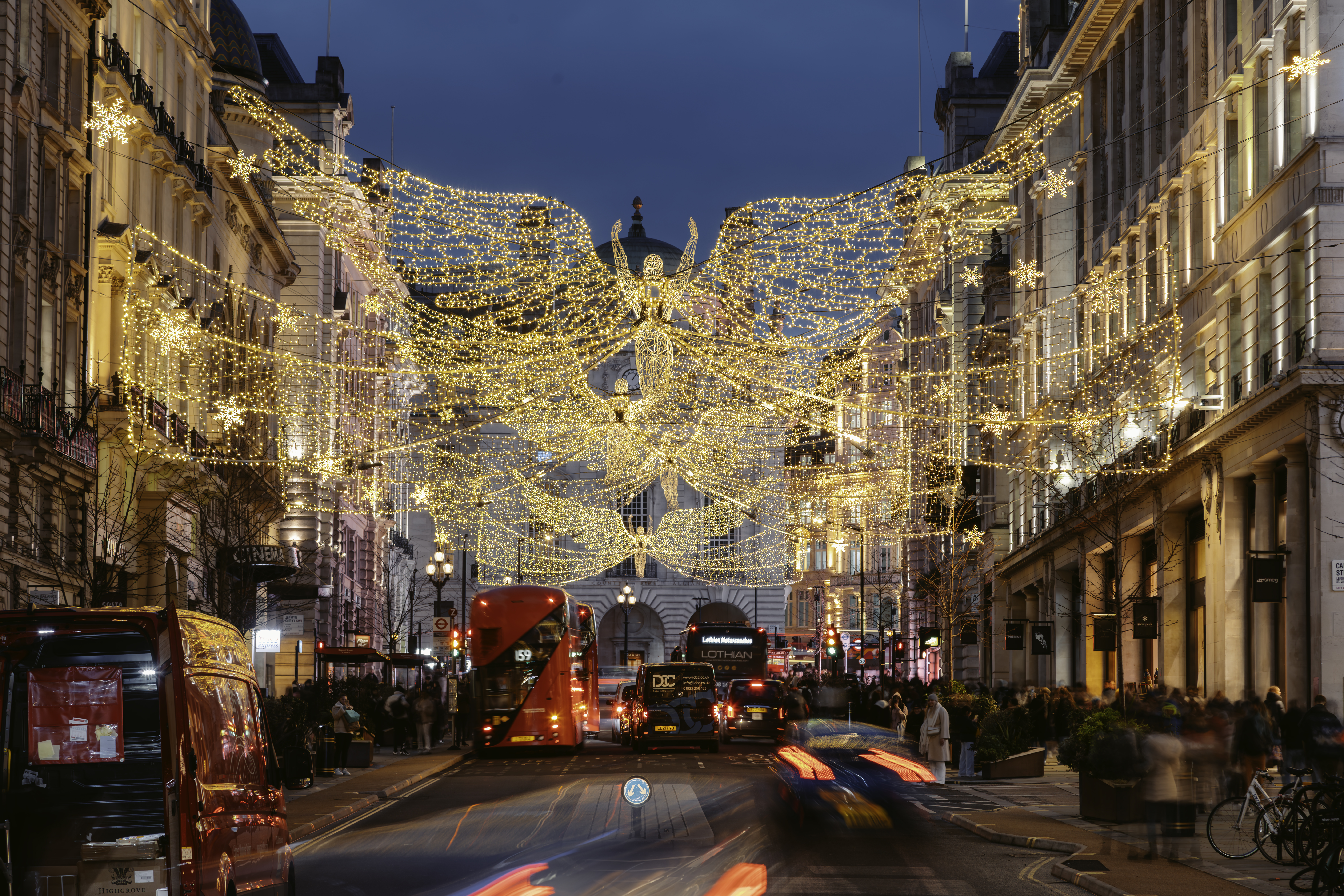 Luces de Navidad en Regent Street, Londres, con ángel alado y tráfico.
