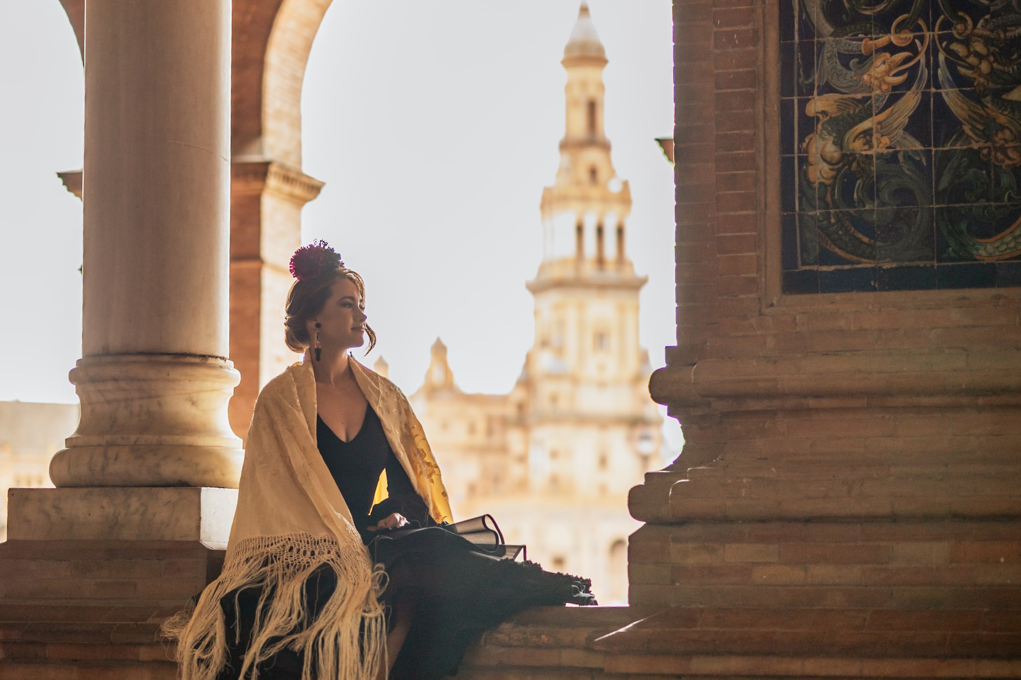 Flamenco woman in black dress and fringed shawl at Plaza de España.