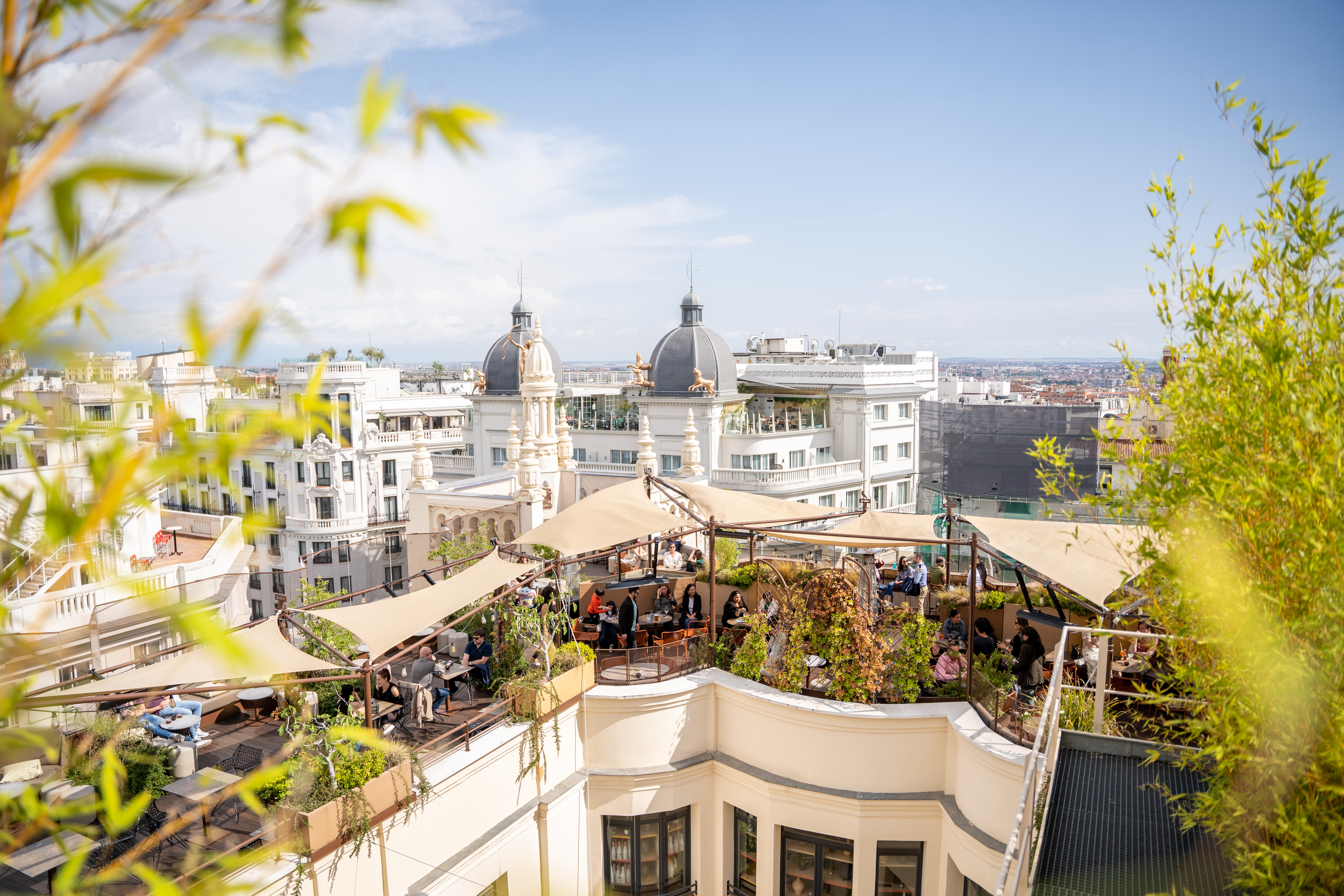a rooftop patio with a group of people sitting on it