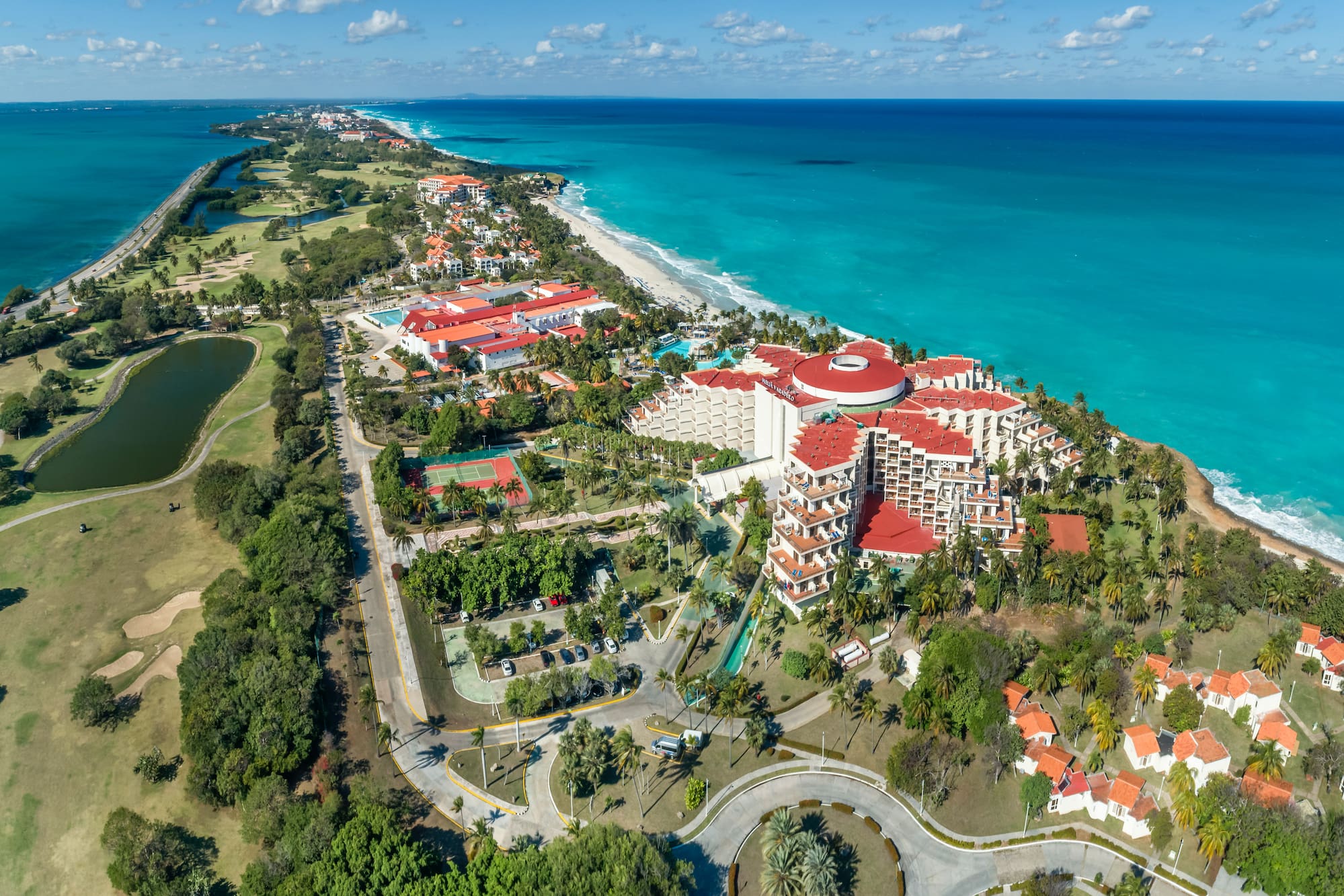 a large resort with a beach and trees