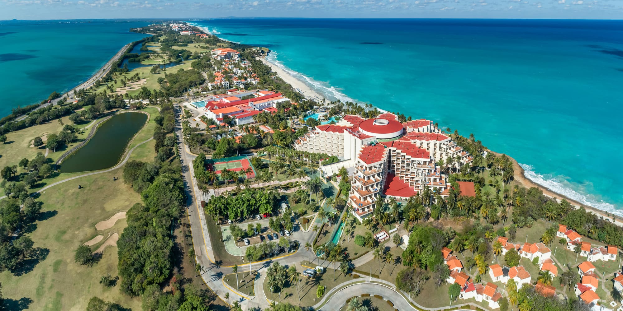 a large resort with a beach and trees