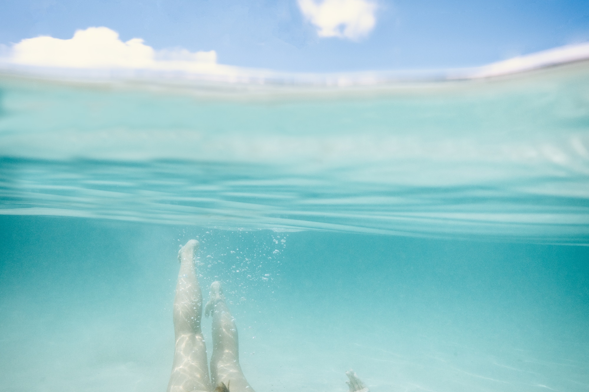 a woman swimming underwater with goggles