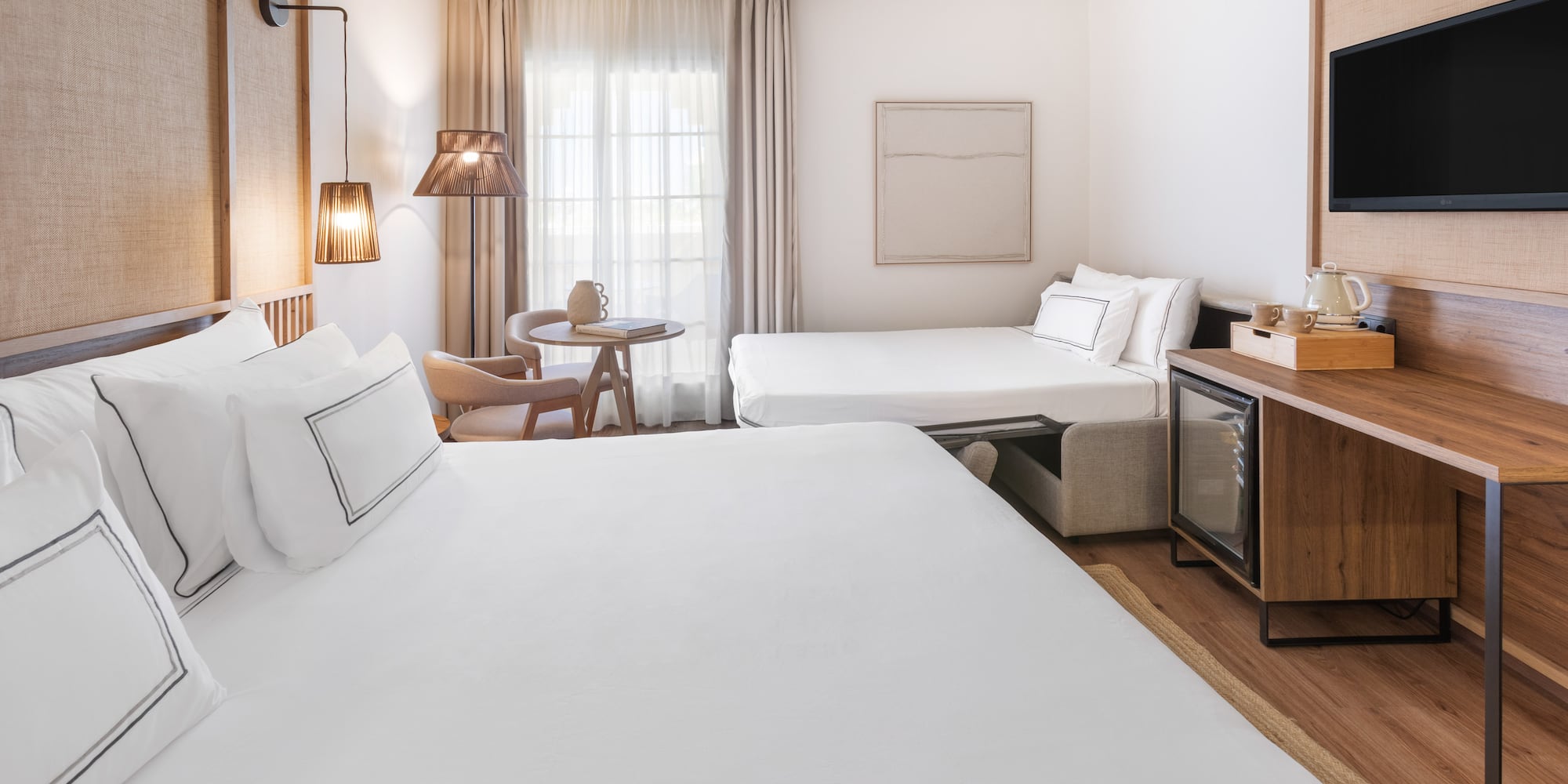 a room with two beds and a television