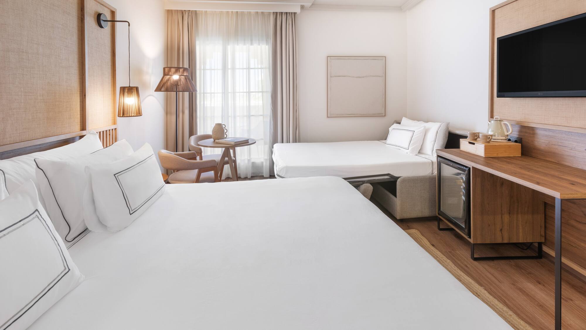 a room with two beds and a television