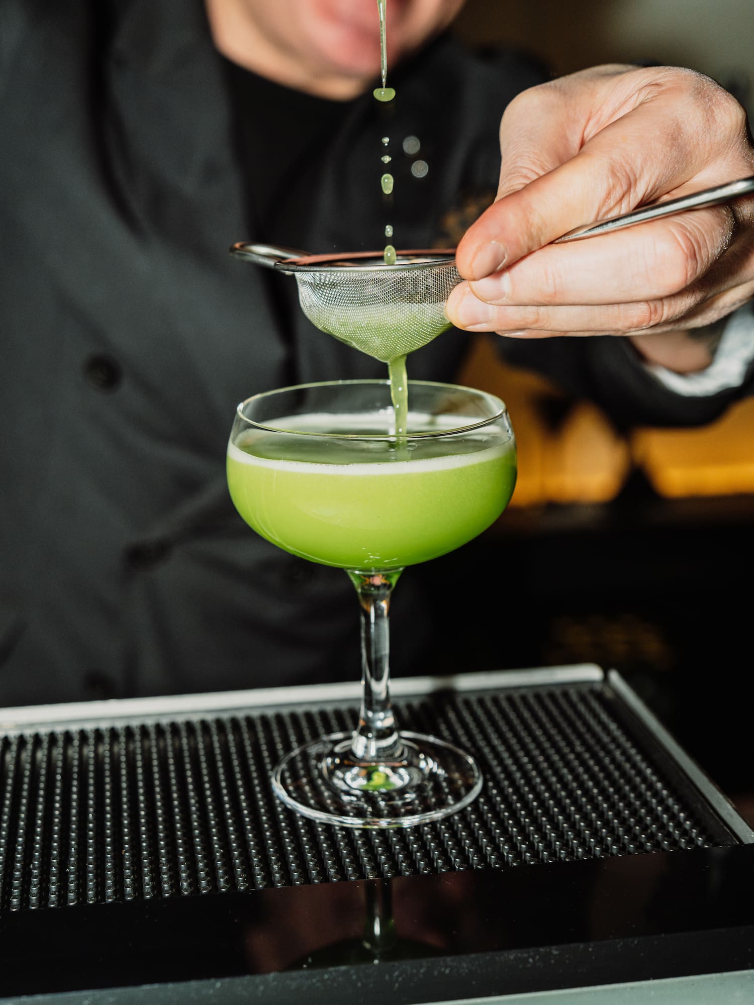 a person pouring a drink into a glass