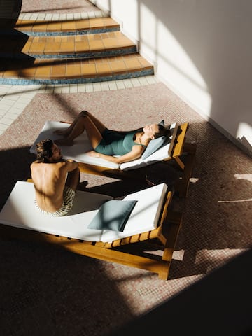 a man and woman lying on lounge chairs