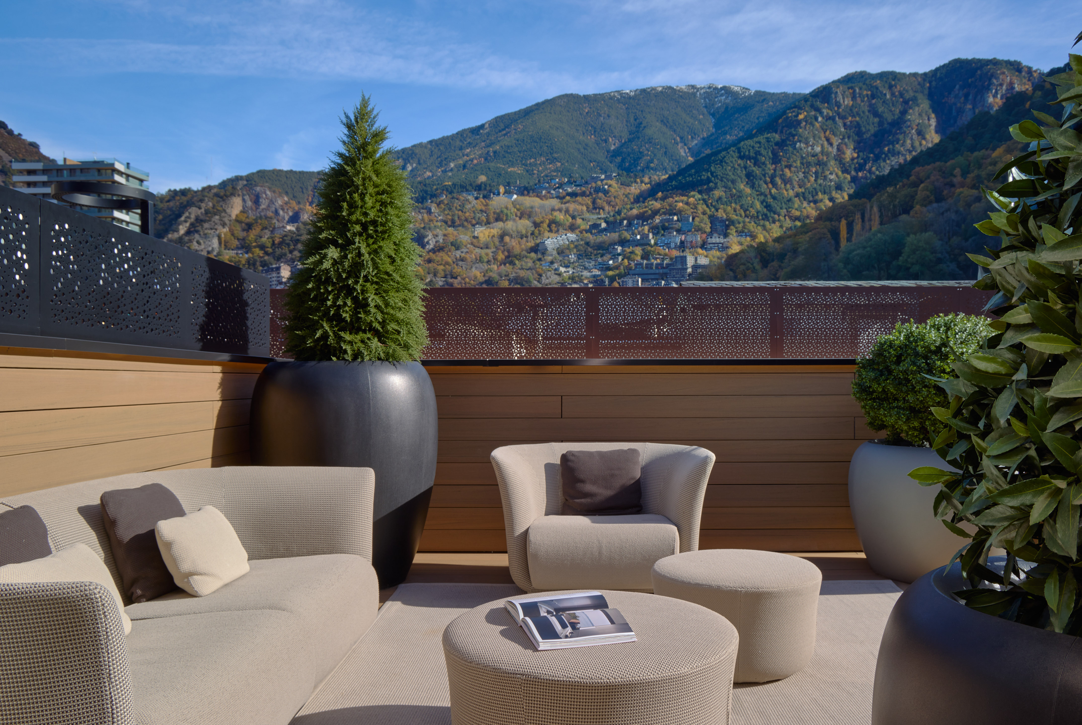 Contemporary outdoor lounge terrace overlooking autumn mountains.