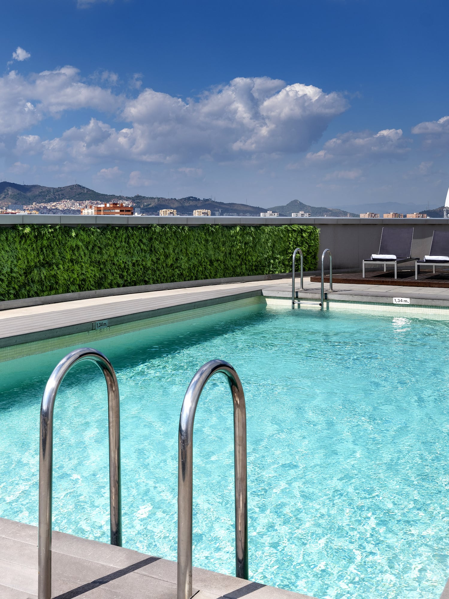 a swimming pool with chairs and a building in the background