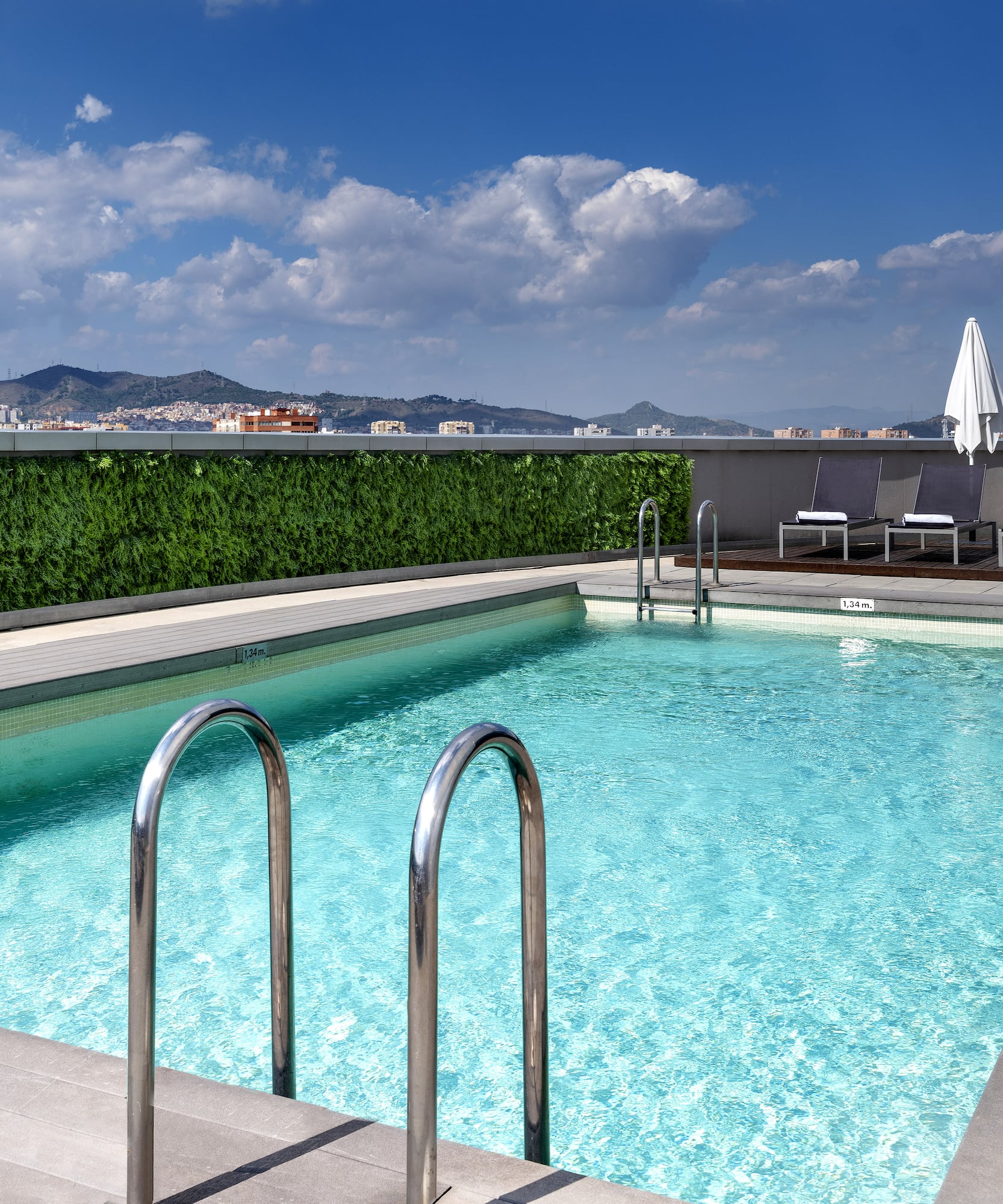 a swimming pool with chairs and a building in the background
