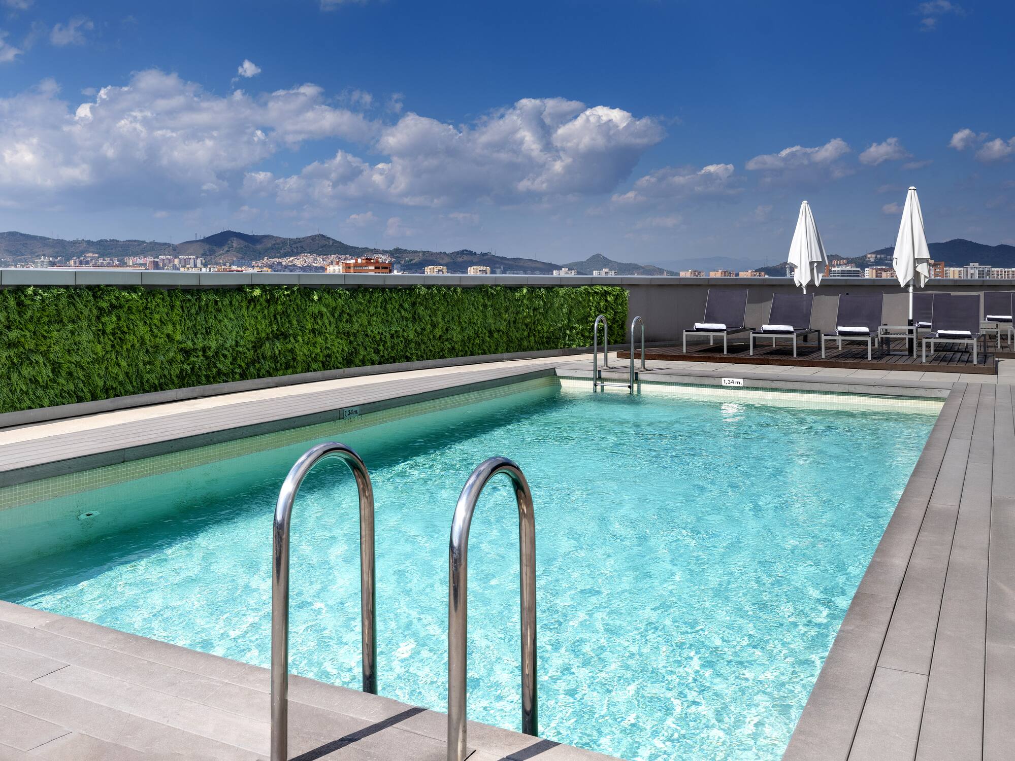 a swimming pool with chairs and a building in the background
