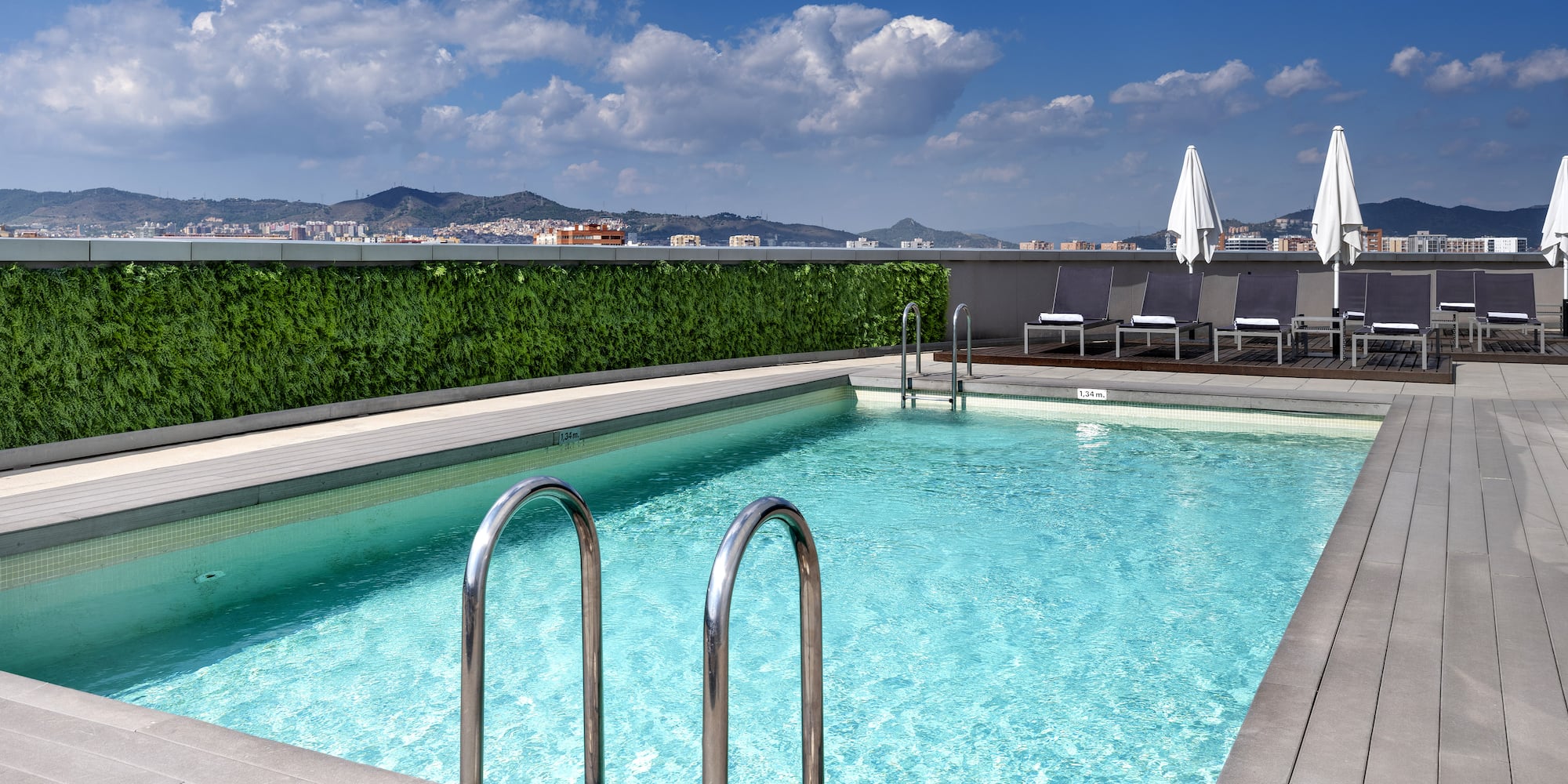 a swimming pool with chairs and a building in the background