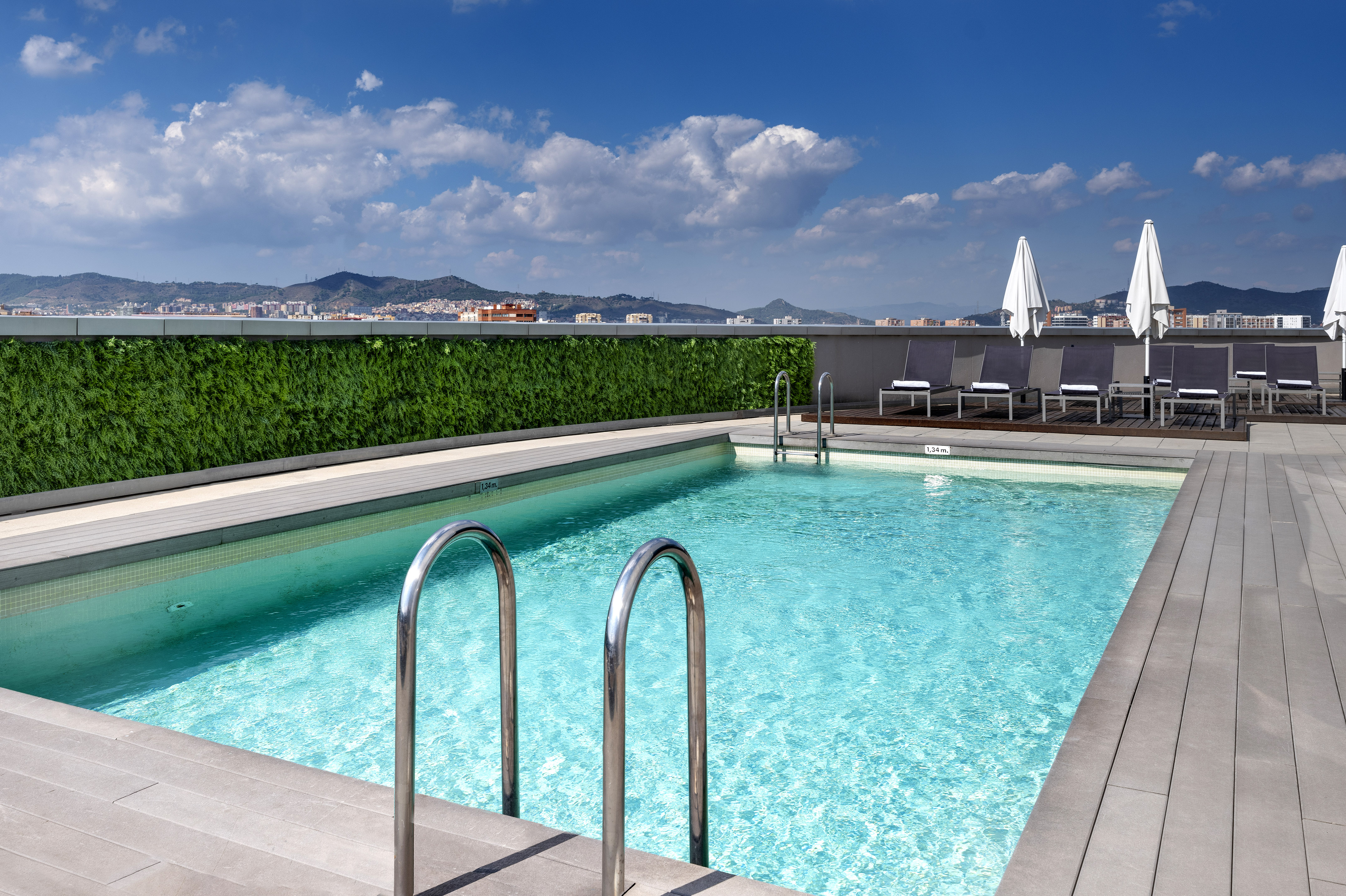 a swimming pool with chairs and a building in the background