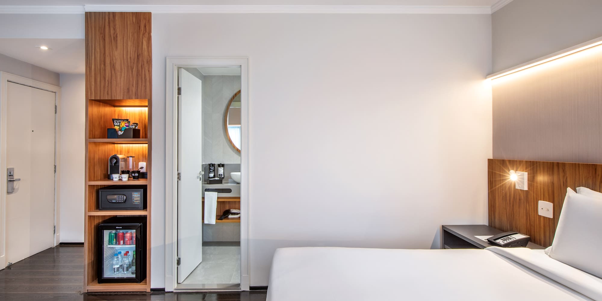 a bedroom with a white bed and a wood cabinet