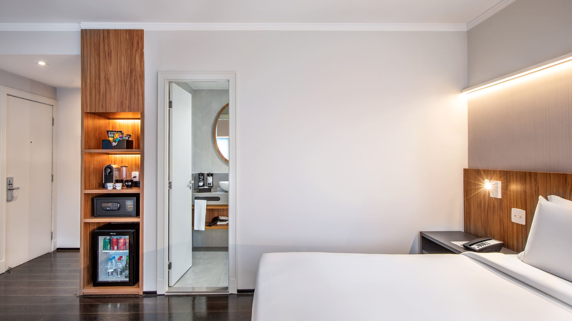 a bedroom with a white bed and a wood cabinet