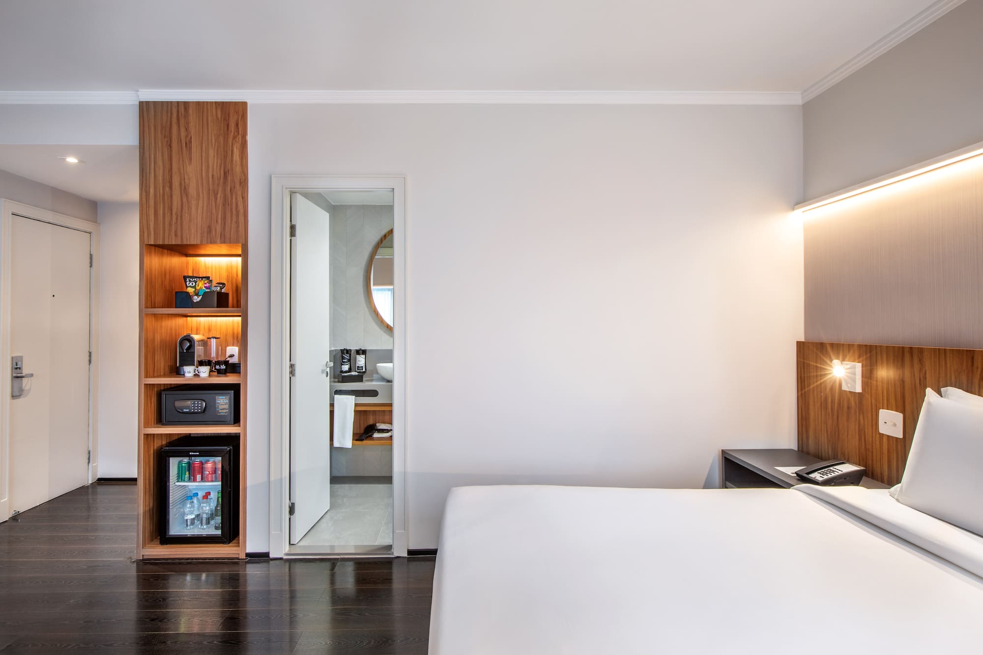 a bedroom with a white bed and a wood cabinet