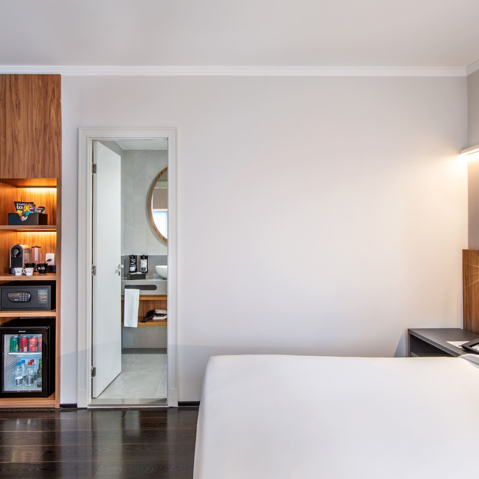 a bedroom with a white bed and a wood cabinet