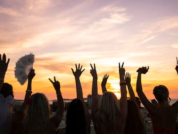 a group of people with their hands up in the air