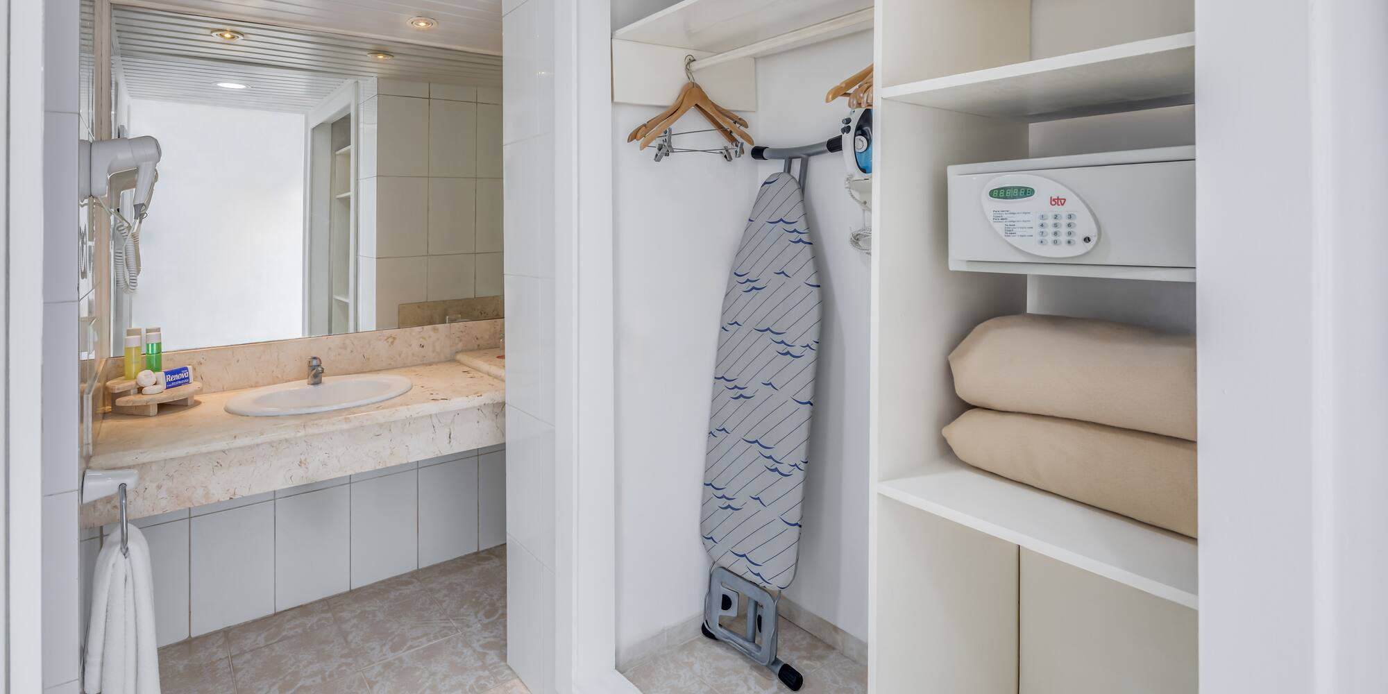 a white bathroom with a ironing board and a sink