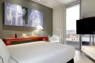 a bedroom with a large window and a large bed