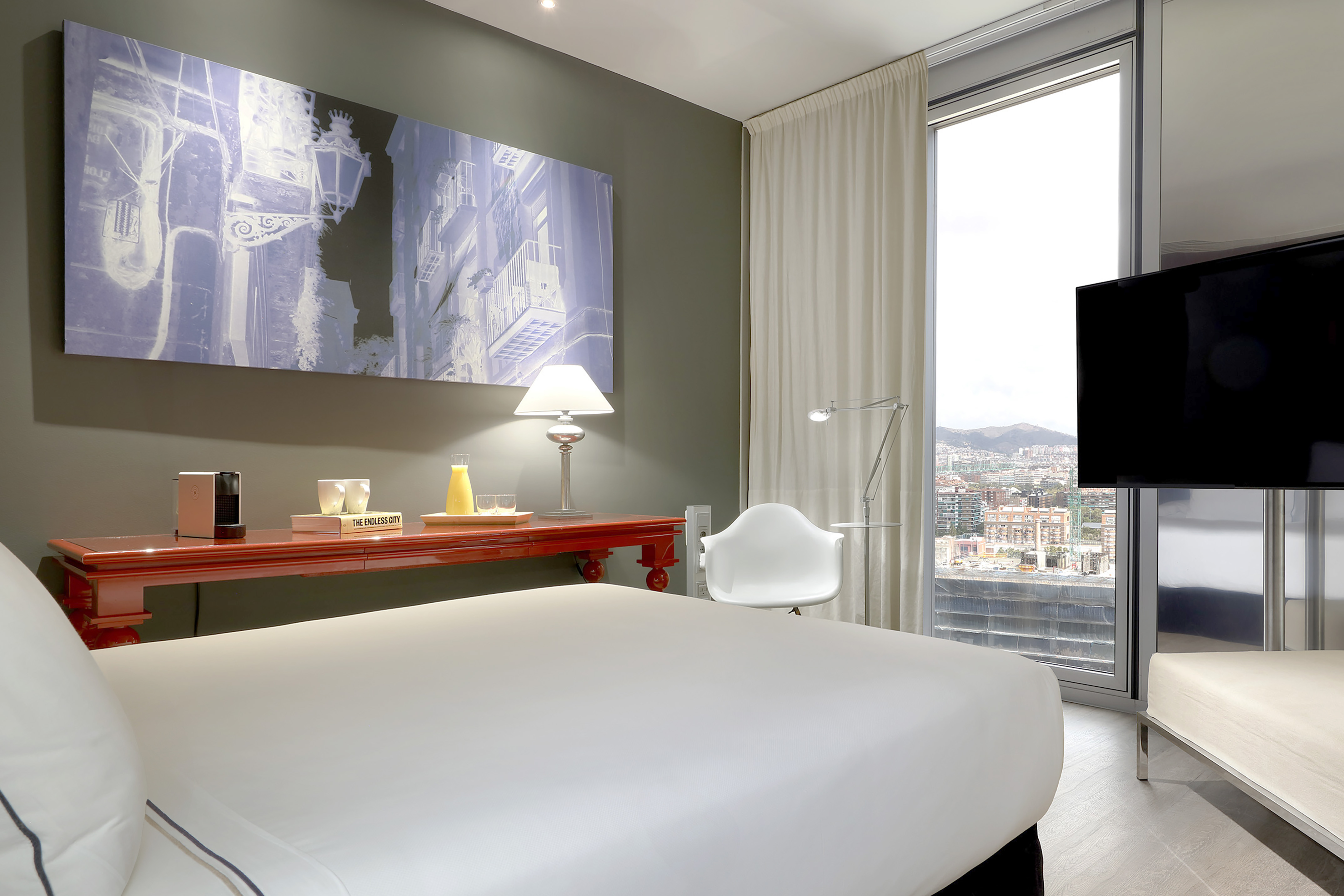 Contemporary hotel room, city view, red desk, and abstract wall art. - The Level Family Suite Vista da Cidade - Meliá Barcelona Sky, Barcelona