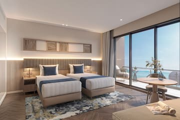 a room with two beds and a table and chairs