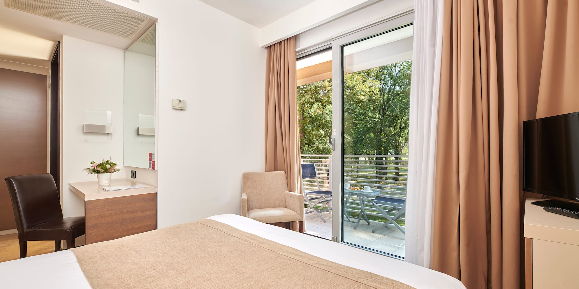 a bed with brown curtains and a glass door