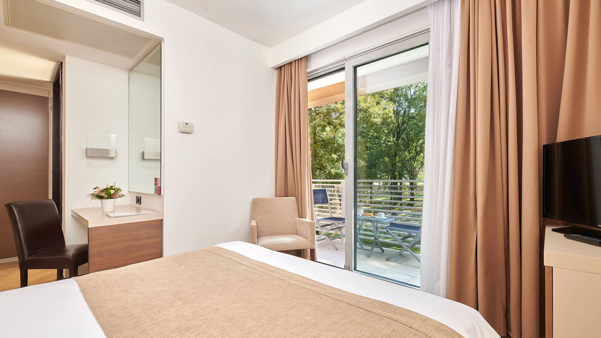 a bed with brown curtains and a glass door
