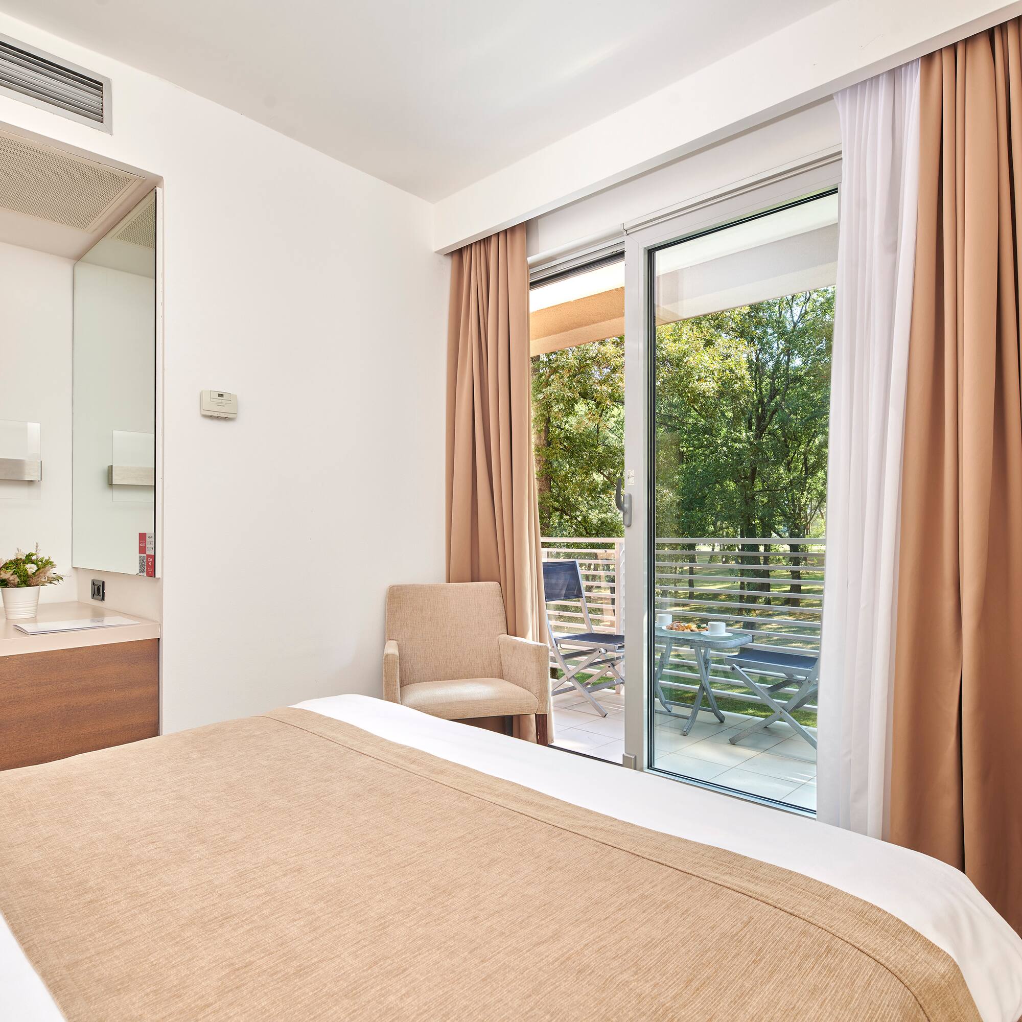 a bed with brown curtains and a glass door