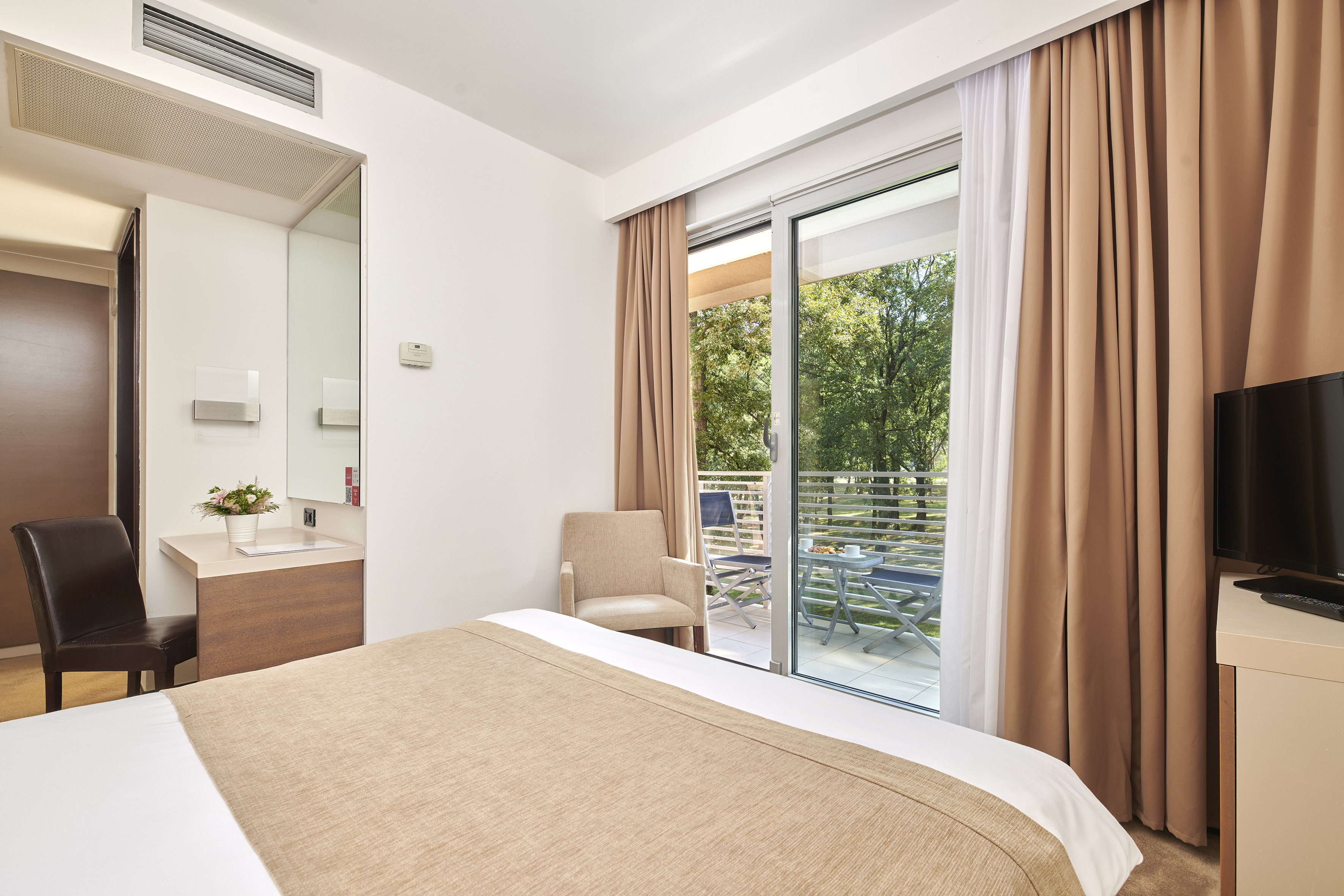 a bed with brown curtains and a glass door