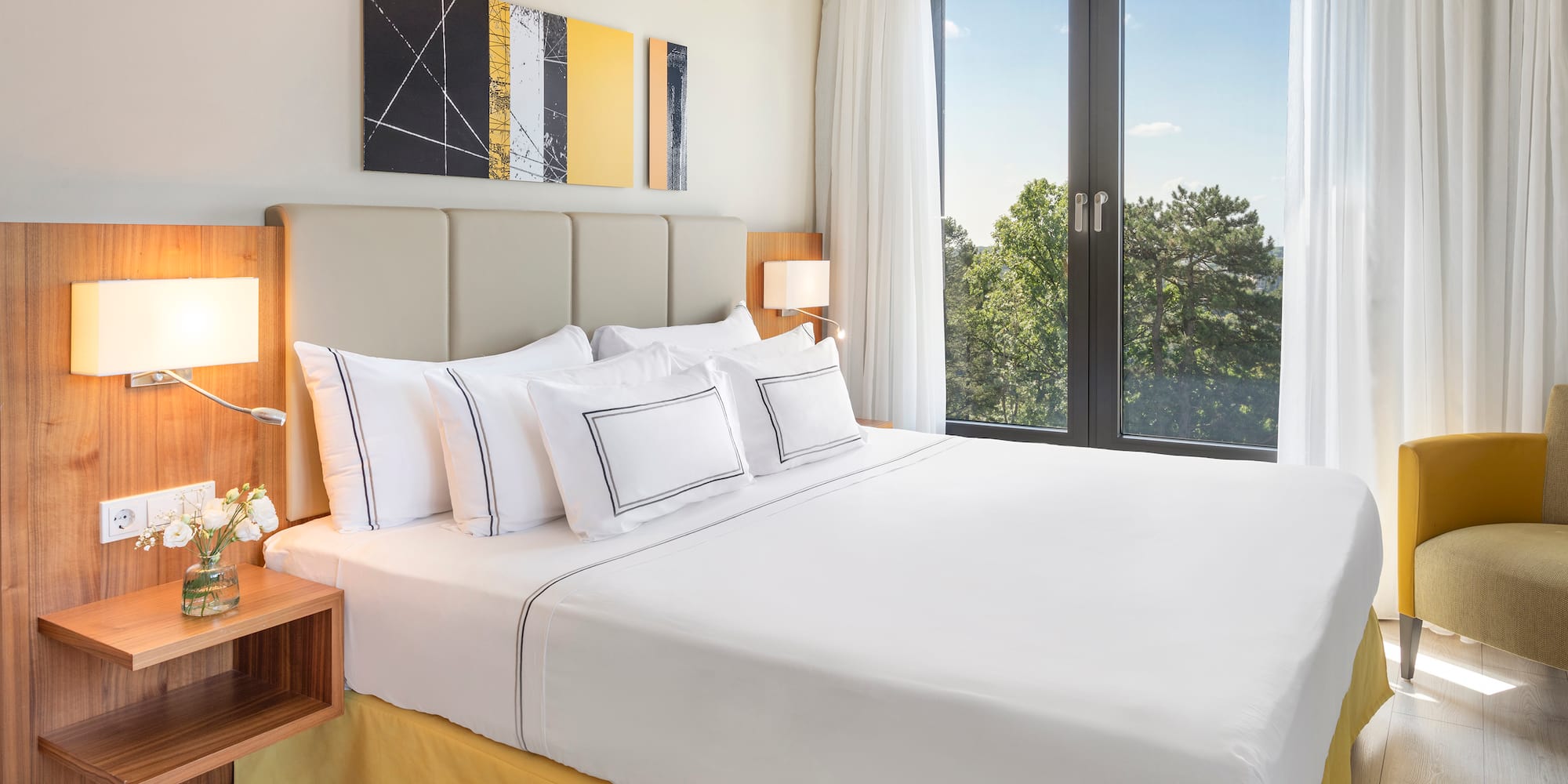 a bed with white sheets and pillows in a room with a window