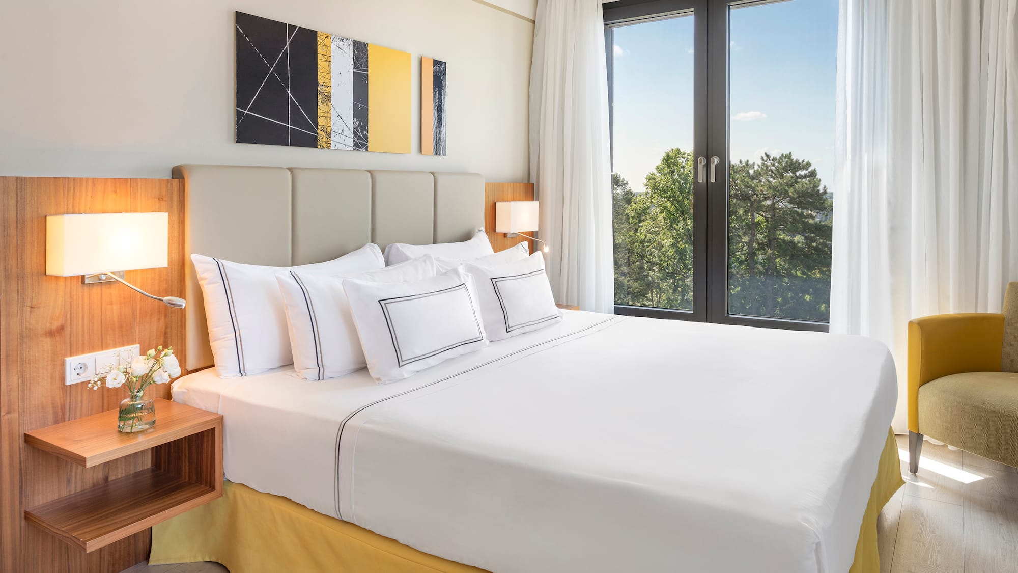 a bed with white sheets and pillows in a room with a window
