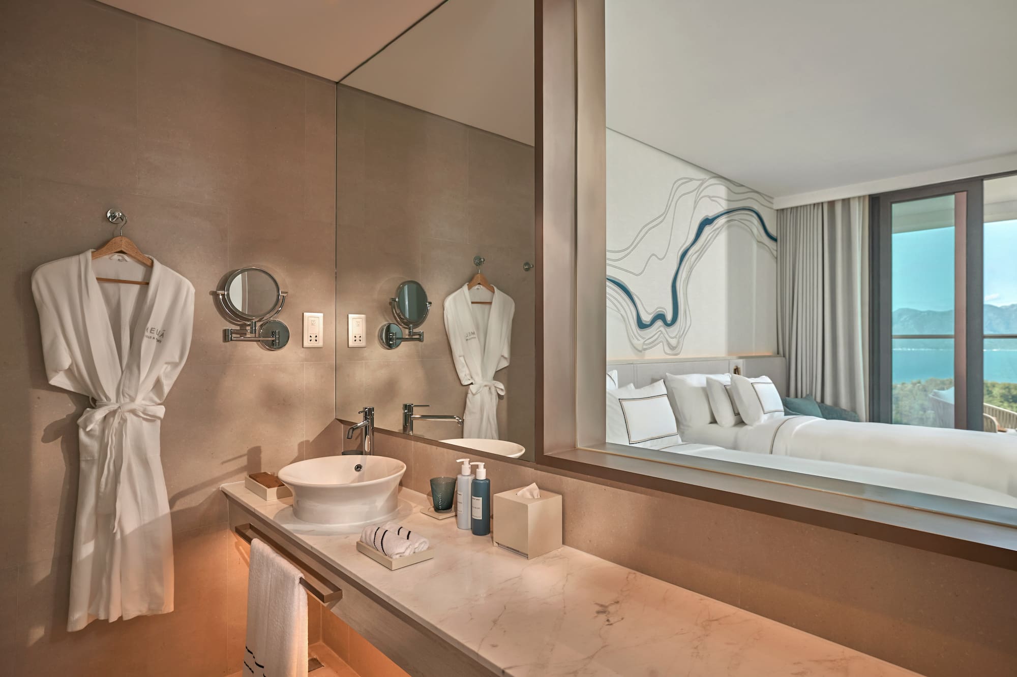 Luxury hotel bathroom vanity, reflecting modern bedroom and ocean view.