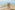 Pareja joven camina descalza en playa tropical junto al mar azul.