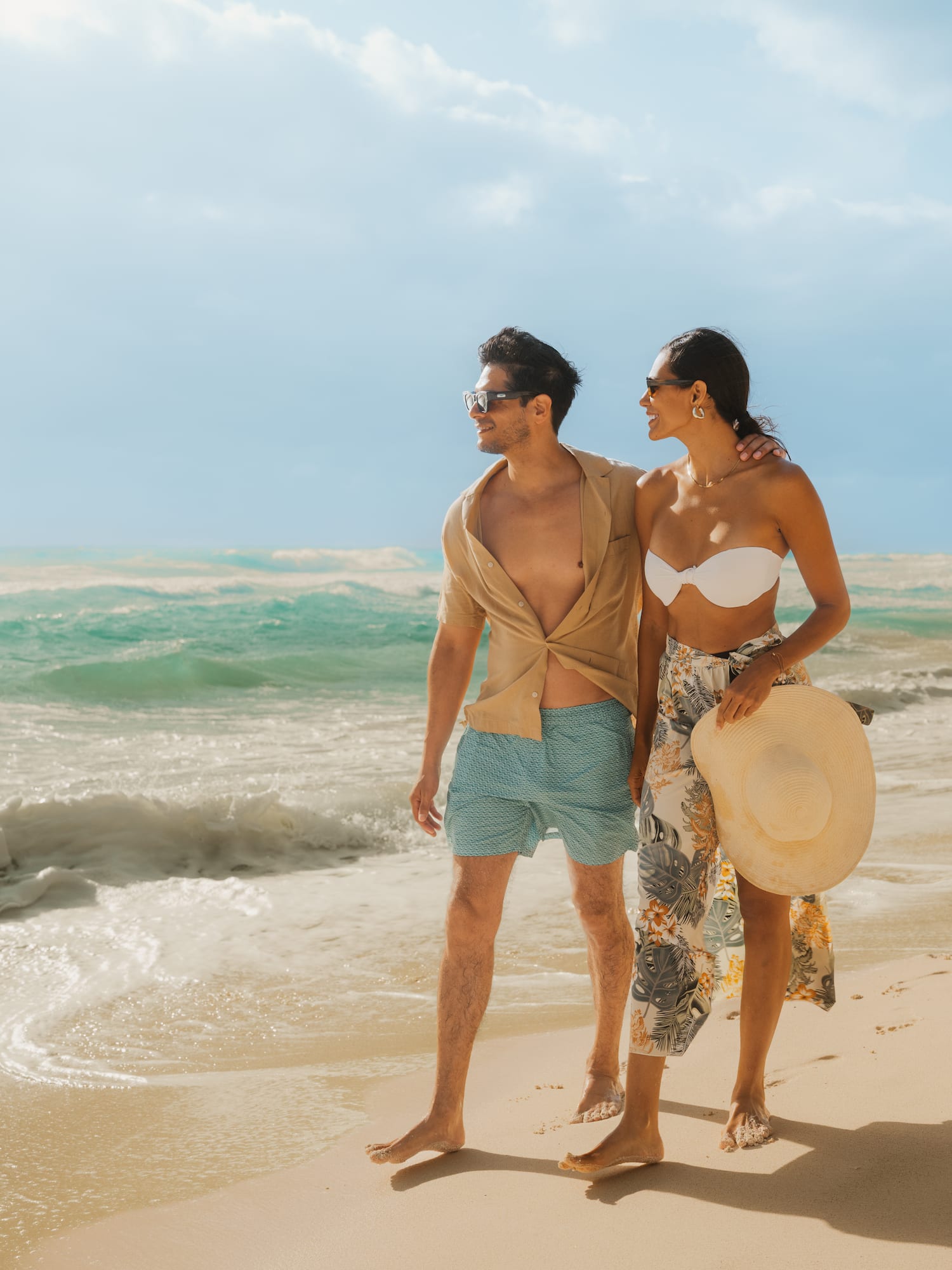 a man and woman walking on a beach