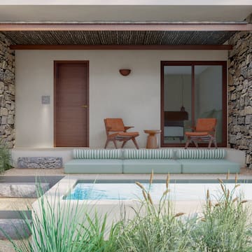 a patio with a pool and chairs