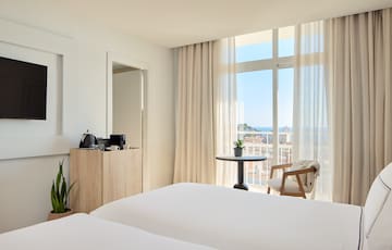 a room with a balcony and a table and chairs