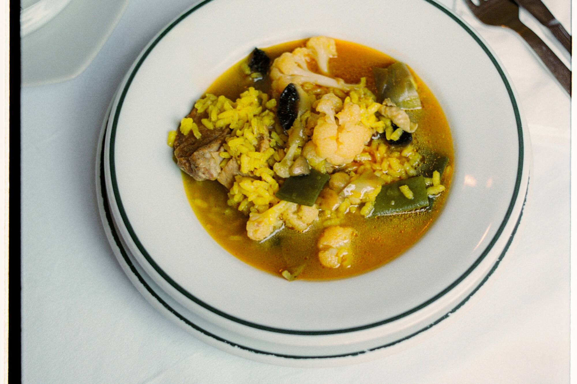 a bowl of soup with rice and vegetables