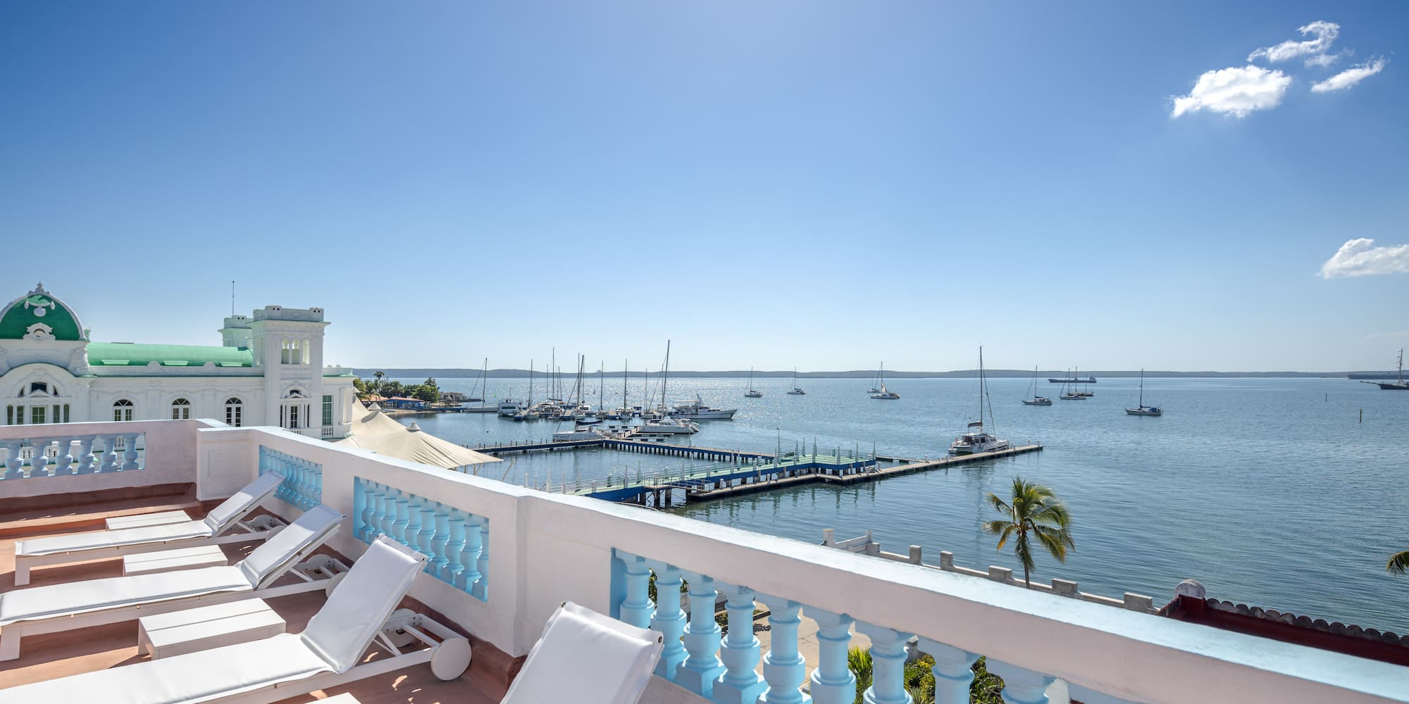 a deck with chairs and a dock in the background