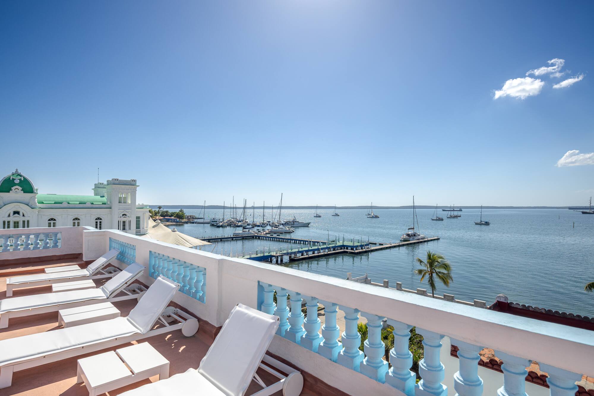 a deck with chairs and a dock in the background