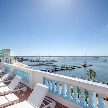 a deck with chairs and a dock in the background