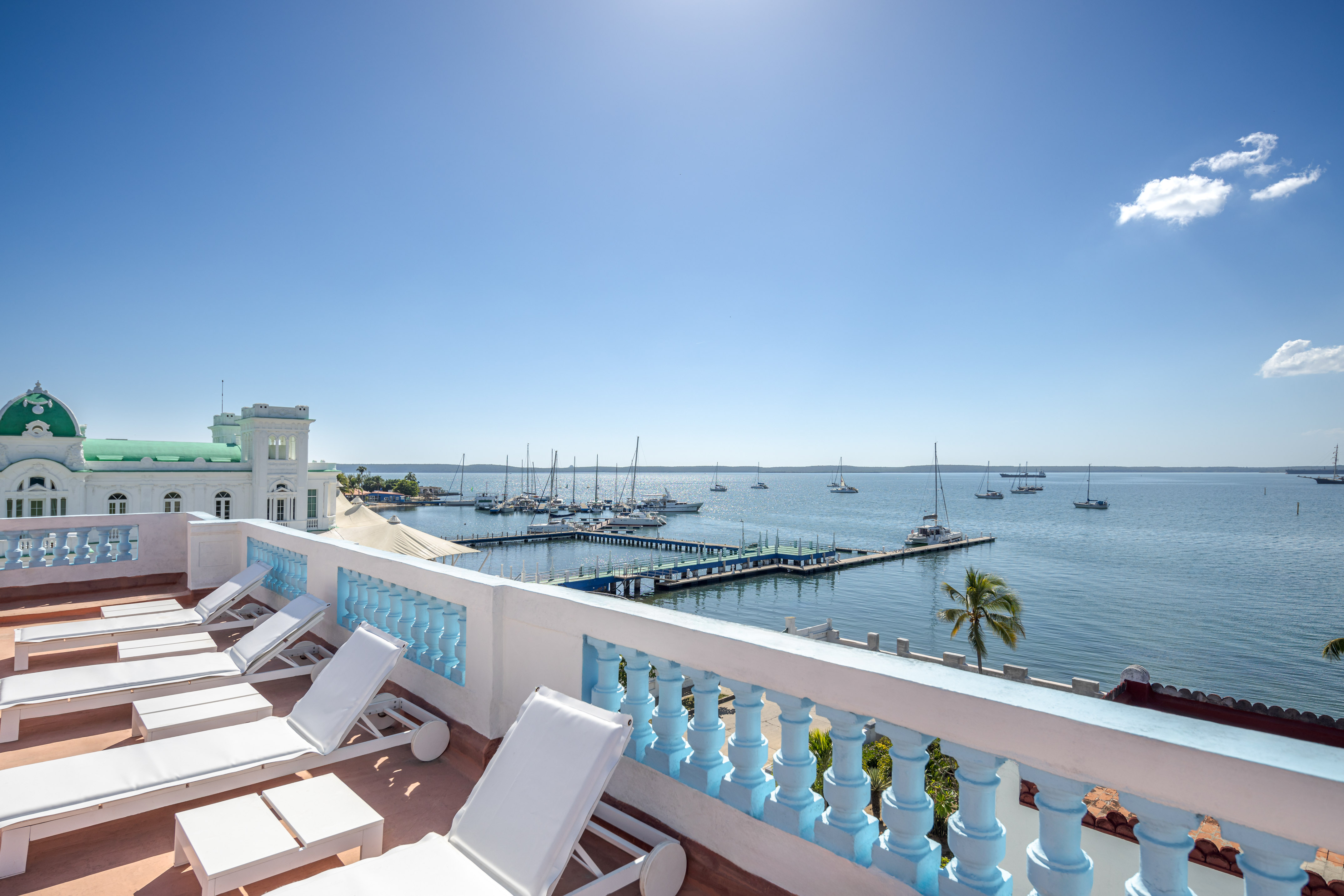 a deck with chairs and a dock in the background