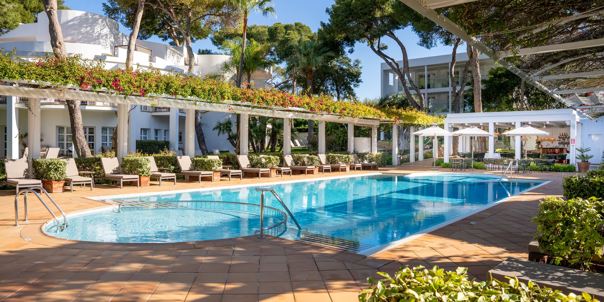 a swimming pool with chairs and umbrellas