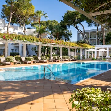 a swimming pool with chairs and umbrellas