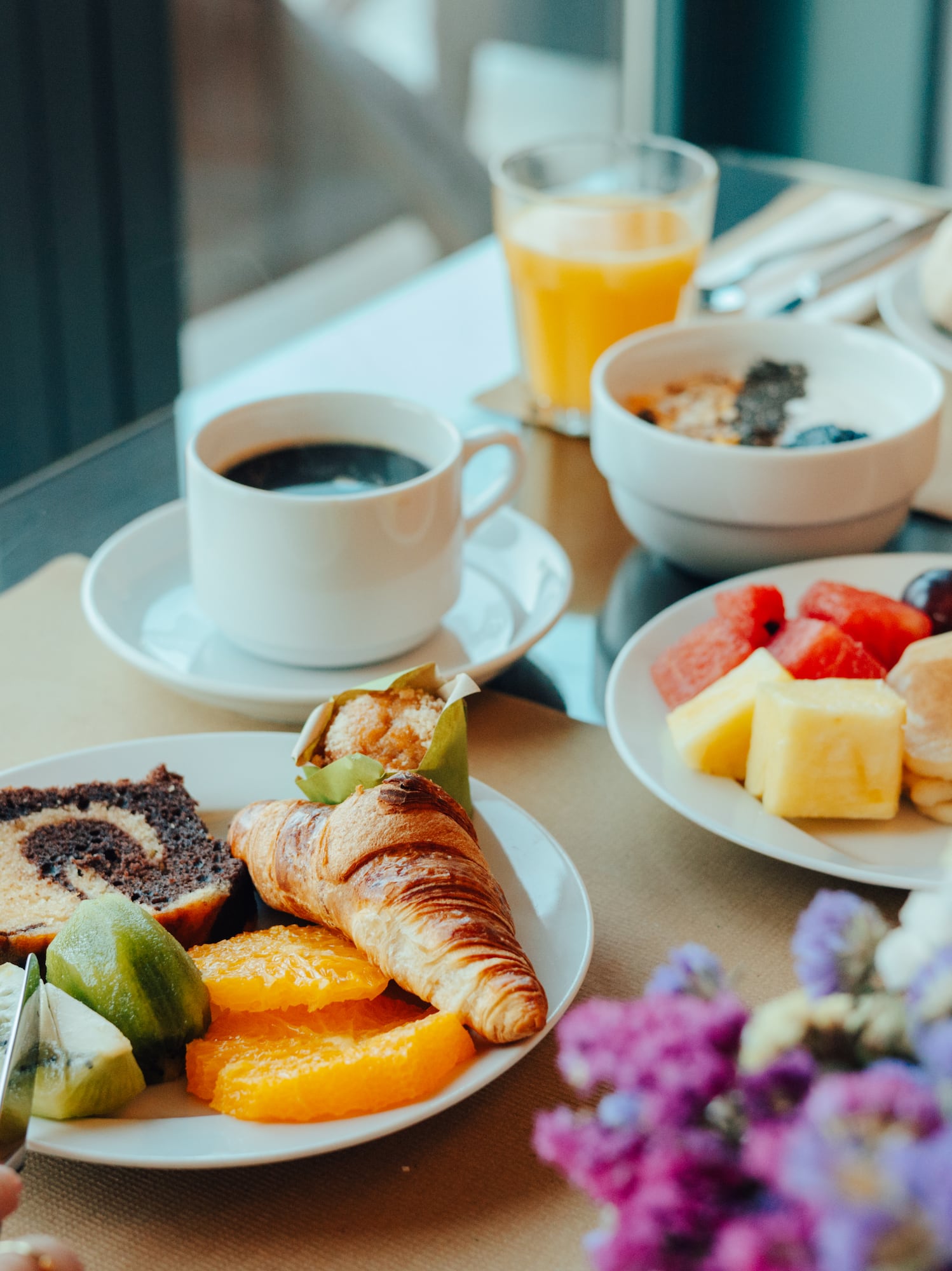 Delicious hotel breakfast with coffee, juice, pastries, fruit, and hot dishes.