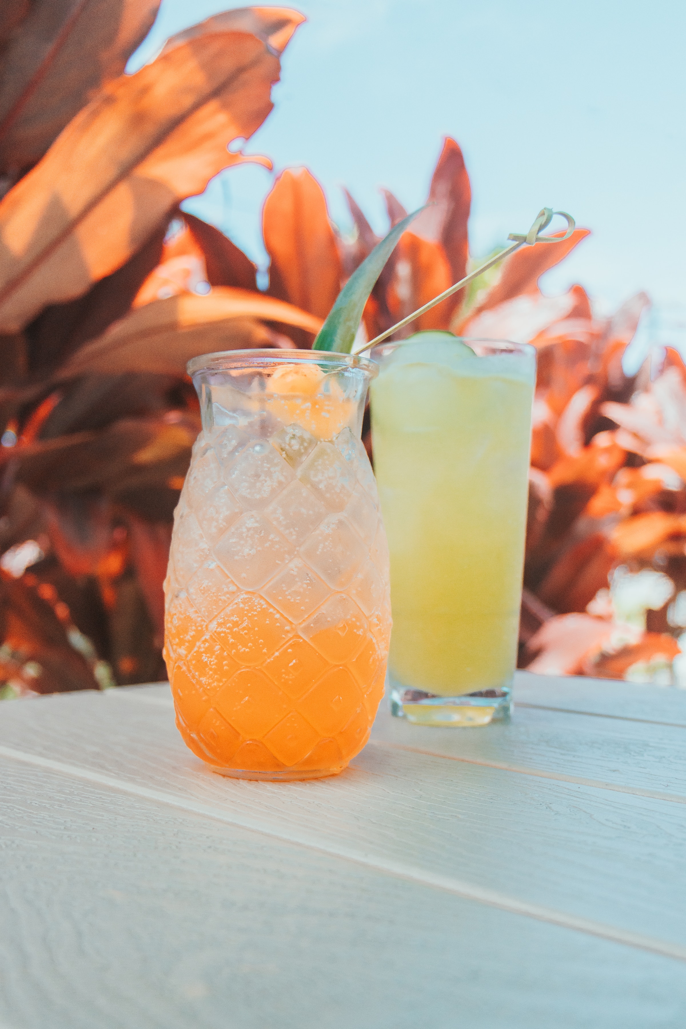 a glass of juice and a drink on a table