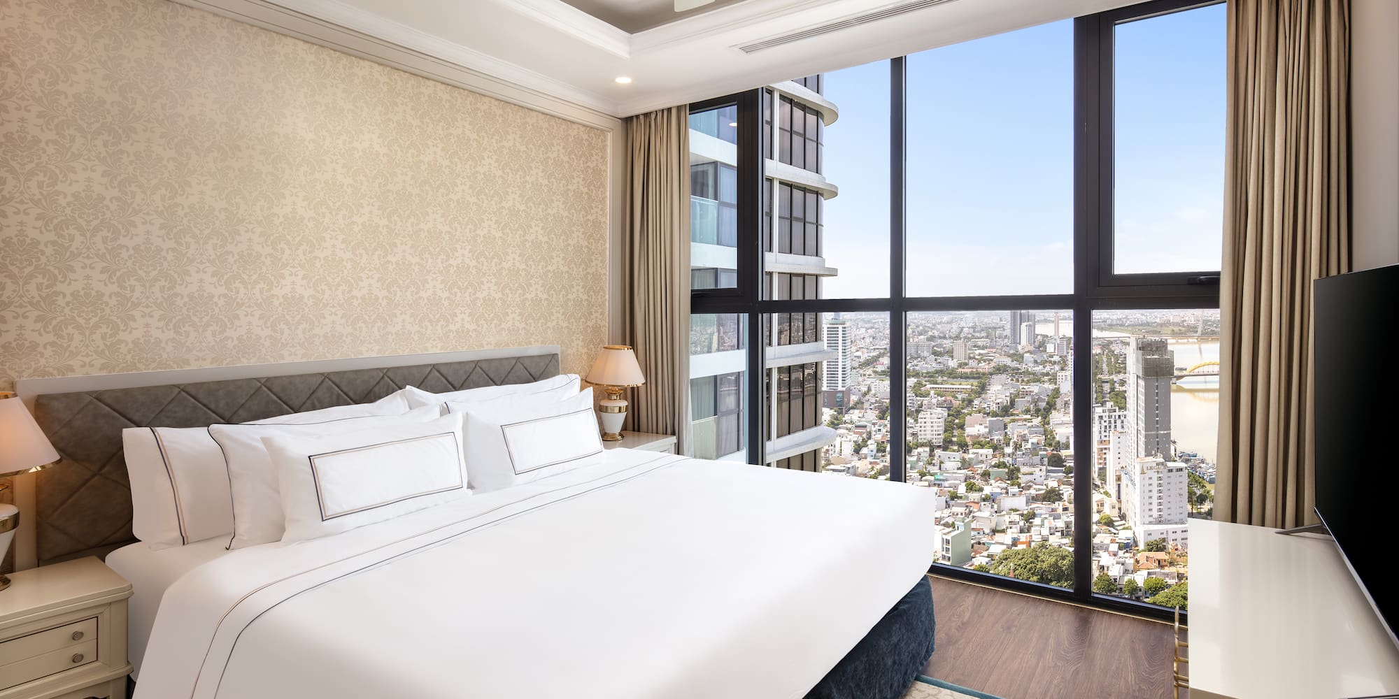 a bedroom with a large window overlooking a city